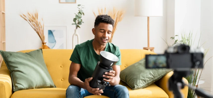 afro-guy-showing-off-a-studio-flash-while-filming-2023-11-27-05-37-26-utc